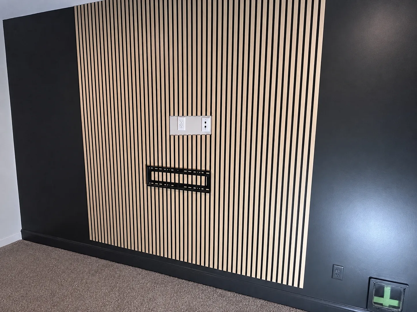 TV mounting bracket aligned over the vertical slat wall during installation