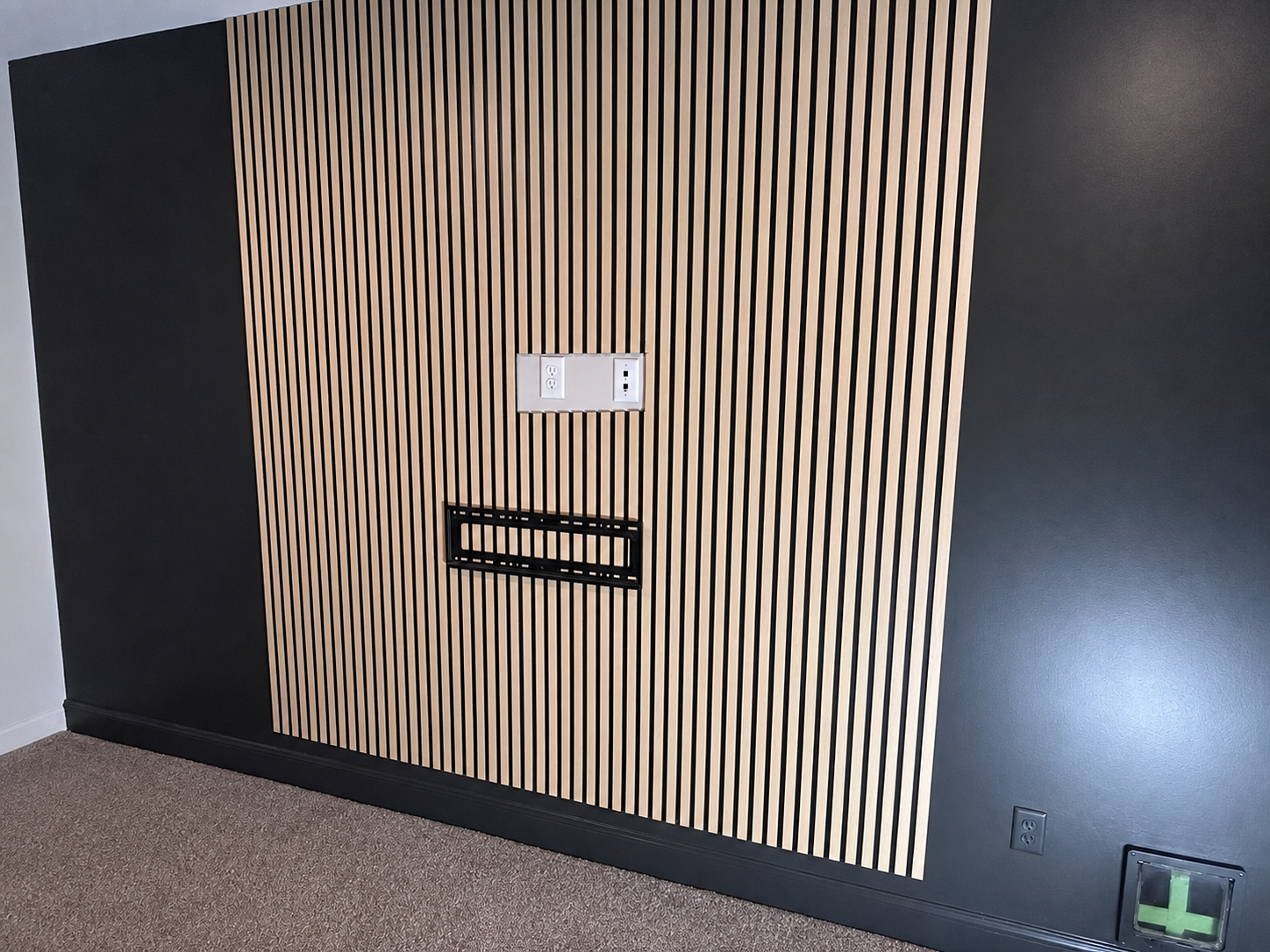 TV mounting bracket aligned over the vertical slat wall during installation