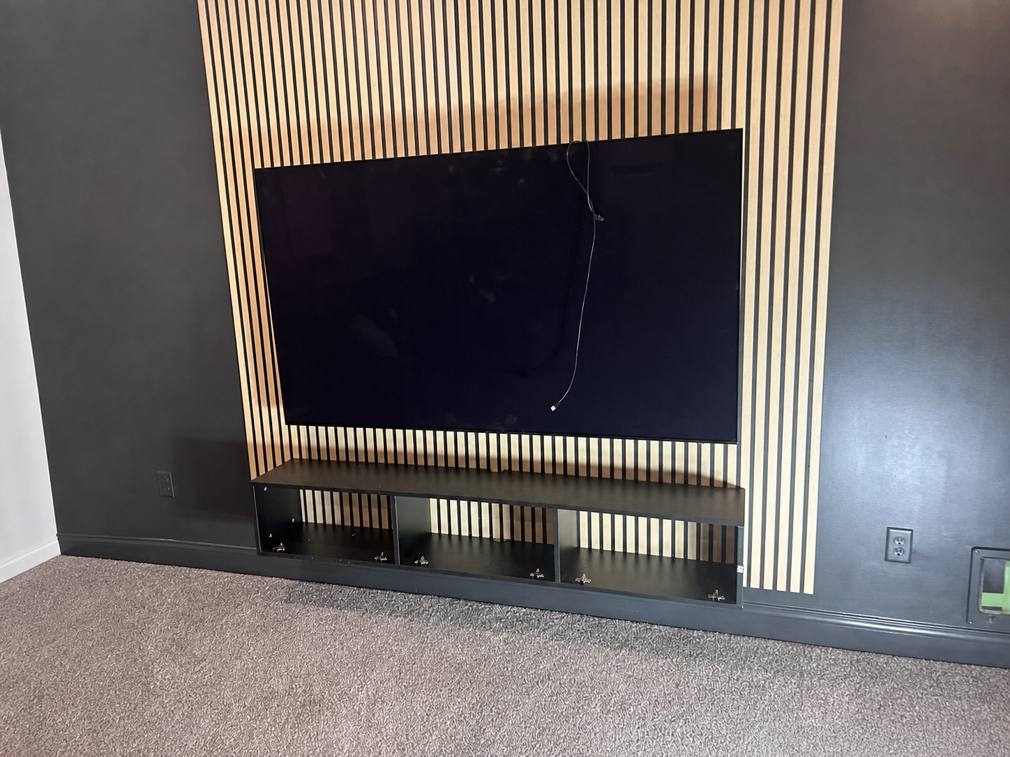 Mounted television and open floating console during the final installation stage